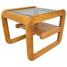 a wooden table with glass top and two shelves on the bottom, against a white background