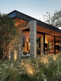 the house is surrounded by tall grass and trees