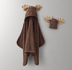 a towel hanging on the wall next to two moose head hooks and a brown towel