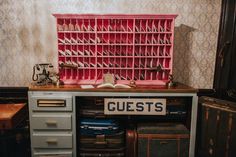 an old desk with lots of suitcases and a sign that says guests on it