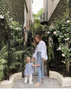 a woman holding the hand of a small child