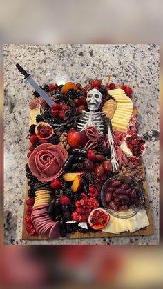 a table topped with lots of different types of food on top of a wooden cutting board