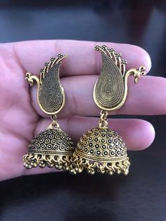 Be unique and make an impact by looking stunning with this antique oxidized peacock earrings with hanging jhumkis made with love💕 for someone special! In stock and ready to ship. Hand crafted and gold plated kundan indian/pakistani jewelry Material:brass,stone,gemstone,pearl We bring you casual as well as party wear jewelry which comes with an attractive design and style. It goes well modern and traditional outfits. Visit my website for more collections https://www.etsy.com/shop/Noorzaracollect Gift Brass Jhumkas With Latkans, Bollywood Oxidized Jhumkas For Wedding, Bollywood Oxidized Finish Jhumkas For Wedding, Ceremonial Brass Jhumkas For Festivals, Heavy Brass Jhumkas, Bollywood Wedding Jhumkas With Oxidized Finish, Antique Chandbali Earrings For Festivals, Brass Jhumkas For Festival Gifts, Brass Dangle Jhumkas For Festivals