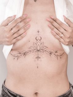 a woman's stomach with tattoos on it and her hands behind her back,