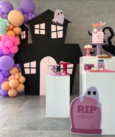 there is a halloween themed party set up with balloons and decorations on the wall behind it