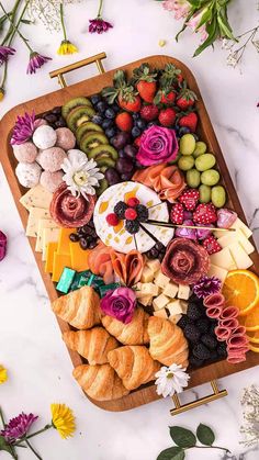 a platter filled with fruit and pastries on top of a marble countertop