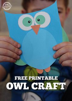 a young boy holding up a paper cutout with an owl on it's face