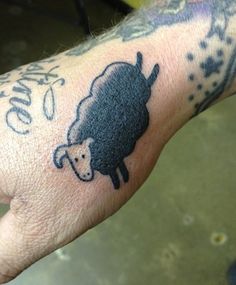 a hand with a black sheep tattoo on it