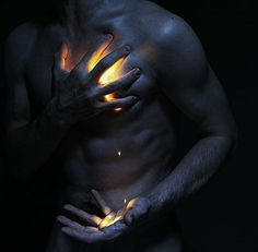 a man with his hands on his chest and glowing fire coming out of his shirt