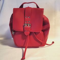 This Wild Fable Mini Flap Backpack is a stylish and practical addition to any outfit. The bag is made of high-quality faux leather, with a solid pattern and a vibrant red exterior color. It features a snap closure, convenient handle/strap, and measures 8.5 inches in width, 9 inches in height, and 4 inches in depth. The backpack is perfect for women who want to stay organized while on-the-go. Its spacious interior is lined with a gray color and can fit all your daily essentials. The backpack is a great choice for those who love the American theme and is made in Cambodia. Trendy Faux Leather Backpack For School, Trendy Leather Crossbody Backpack For School, Faux Leather School Backpack, Red Faux Leather Travel Bag, School Backpack With Adjustable Straps In Faux Leather, Casual Faux Leather Backpack With Adjustable Strap, School Backpack With Adjustable Strap And Faux Leather, Trendy Faux Leather Shoulder Backpack, Trendy Faux Leather Backpack