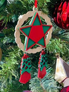 an ornament hanging from a christmas tree decorated with red, green and gold ornaments