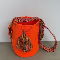 Authentic Wayuu Tribe Cross Body Bag. Vibrant Colors Hand Sown In Colombia. Approximately 11 Inches In Height And 12 Inches Wide. Strap Is 44 Inches In Length (Approx ~21.5 Inches Once You Use It On Your Shoulder). Great For Any Occasion! Boho Style Bag, Neon Bag, Crossover Bags, Wayuu Bag, Rug Bag, Handcrafted Bags, Tassel Bag, Orange Bag, Purple Bags