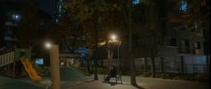 a person sitting in a chair on a playground at night