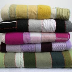 towels stacked on top of each other in different colors and patterns, all folded neatly