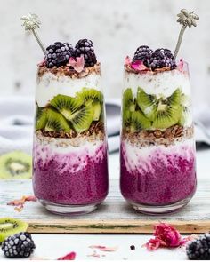 two glasses filled with food sitting on top of a table