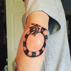 a man's arm with a snake tattoo on it, and the letter c