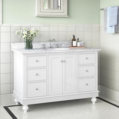 a white bathroom vanity with two sinks and mirrors