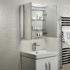 a bathroom with a sink, mirror and towel rack