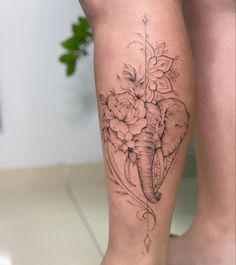 a woman's leg with an elephant and flowers tattoo on the side of her calf