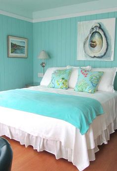 a bedroom with blue walls and white bedding