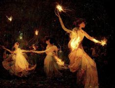 three women in long dresses are holding sparklers