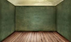 an empty room with green walls and wooden floors