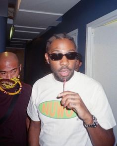 two men standing next to each other in front of a door and one holding a toothbrush