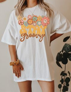 a woman standing in front of a plant wearing a white t - shirt that says grooy