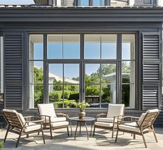 three chairs and a table in front of a large window