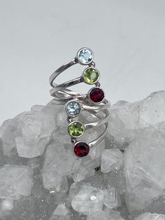 Multi-Gemstone Ring, Size -Various Adjustable Garnet, Peridot, and Blue Topaz 925 Sterling Silver WWW.KARINSFORGOTTENTREASURES.COM Multi-stone Round Jewelry For May Birthstone, Round Peridot Jewelry With Stones, Round Peridot Stone Jewelry, Peridot Multi-stone Rings For May Birthstone, Peridot Jewelry With Gemstone Accents, Round Multi-stone Gemstones For May Birthstone, Sterling Silver Topaz Gemstone Ring, Sterling Silver Multi-stone Jewelry, Sterling Silver Multi-stone Round Jewelry