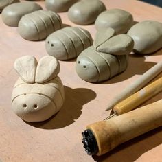 some clay animals are sitting on a table next to rolling pins and wooden utensils