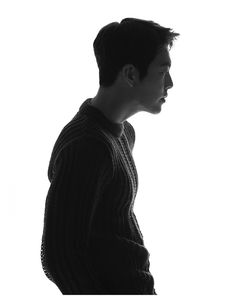 a black and white photo of a man in a sweater looking off to the side