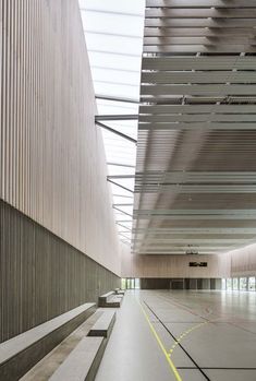 the inside of an empty building with concrete floors and benches on either side of it