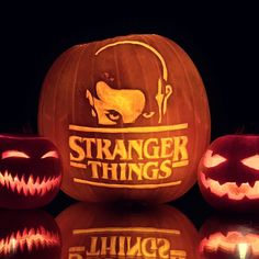 three pumpkins with the words strange things carved into them