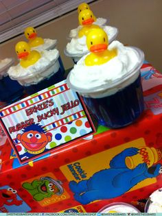 there are some cupcakes with rubber ducks on them and one has a card