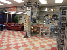 the inside of a store with checkered flooring and red leather chairs in it