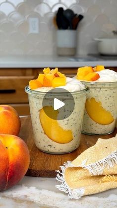 peaches and yogurt in small glass bowls on a wooden cutting board with a towel next to them