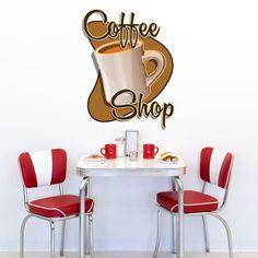 there is a coffee shop sign on the wall above two red chairs and a white table