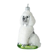 a white poodle ornament with a cucumber on it's back