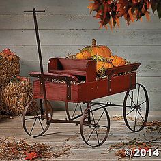 a wagon filled with pumpkins sitting on top of a wooden floor