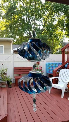 a wind chime hanging from the side of a wooden deck