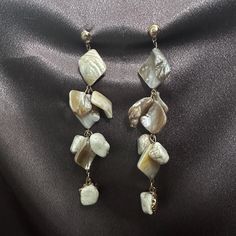 Add a touch of the ocean to your style with these stunning handmade shell and gold alloy dangle earrings. Perfect for those who love bohemian and nature-inspired jewelry, these earrings feature an elegant combination of natural stones and uniquely shaped shells, creating a beautiful and unique statement piece. The earrings are designed with a mix of creamy white shells, polished stones, and golden alloy accents, capturing the essence of a serene beachside walk. These earrings are lightweight, making them comfortable to wear all day long, whether you're headed to a summer festival, a casual day out, or a beach vacation. These earrings also make a great gift for someone who loves the ocean, nature, or bohemian style. Perfect for birthdays, holidays, or any special occasion. Each piece is han Gold Shell Dangle Earrings, Dangle Shell Earrings With Pearl Drop, Dangle Pearl Drop Shell Earrings, Elegant Shell Dangle Earrings, Elegant Shell Drop Earrings, Pearl Drop Dangle Shell, Elegant Dangle Shell Earrings, Elegant Dangle Shell, Bohemian Mother Of Pearl Drop Earrings