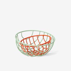 an orange and green wire basket on a white background