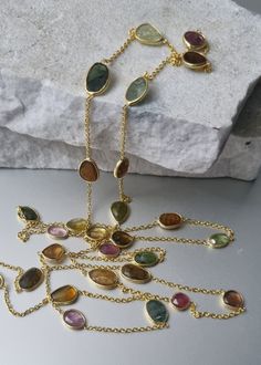 Perfect slices of genuine natural Tourmaline, in a myriad of shades. all stones are slices and have been rose-cut. included is Green, Pink Tourmaline, Brown, Golden etc...just stunning. The striking 14k gold vermeil provides the perfect contrast to the Tourmaline gem. No cheap metals - just 925 Sterling Silver with 14k gold plate. What may look like cracks in the gemstone, are actually natural inclusions. Length is 36 inches. Lobster clasp. Multicolor Tourmaline Jewelry With Stones, Oval Tourmaline Natural Gemstones, Oval Tourmaline Gemstones, Gold Tourmaline Multi-stone Necklace, Gold Multi-stone Tourmaline Necklaces, Yellow Gold Tourmaline Necklace With Natural Stones, Paste Jewelry, Flapper Necklace, Pink Brown