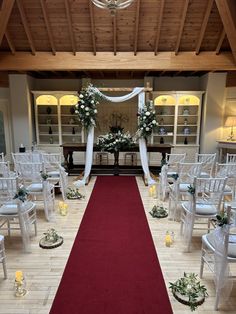 the aisle is decorated with white flowers and greenery as well as candles for an elegant wedding ceremony