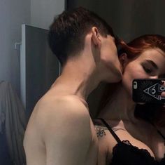 a man and woman taking a selfie in the mirror