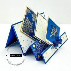 three folded cards with snowflakes on them, one is blue and the other is white