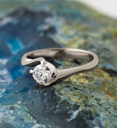 a diamond ring sitting on top of a rock