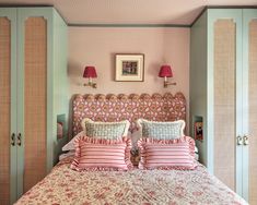 a bedroom with pink and white bedding, two lamps on either side of the headboard