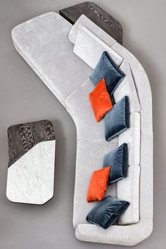 a white couch with orange and blue pillows